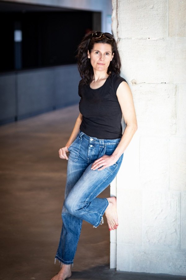 In Jeans an eine Wand gelehnt